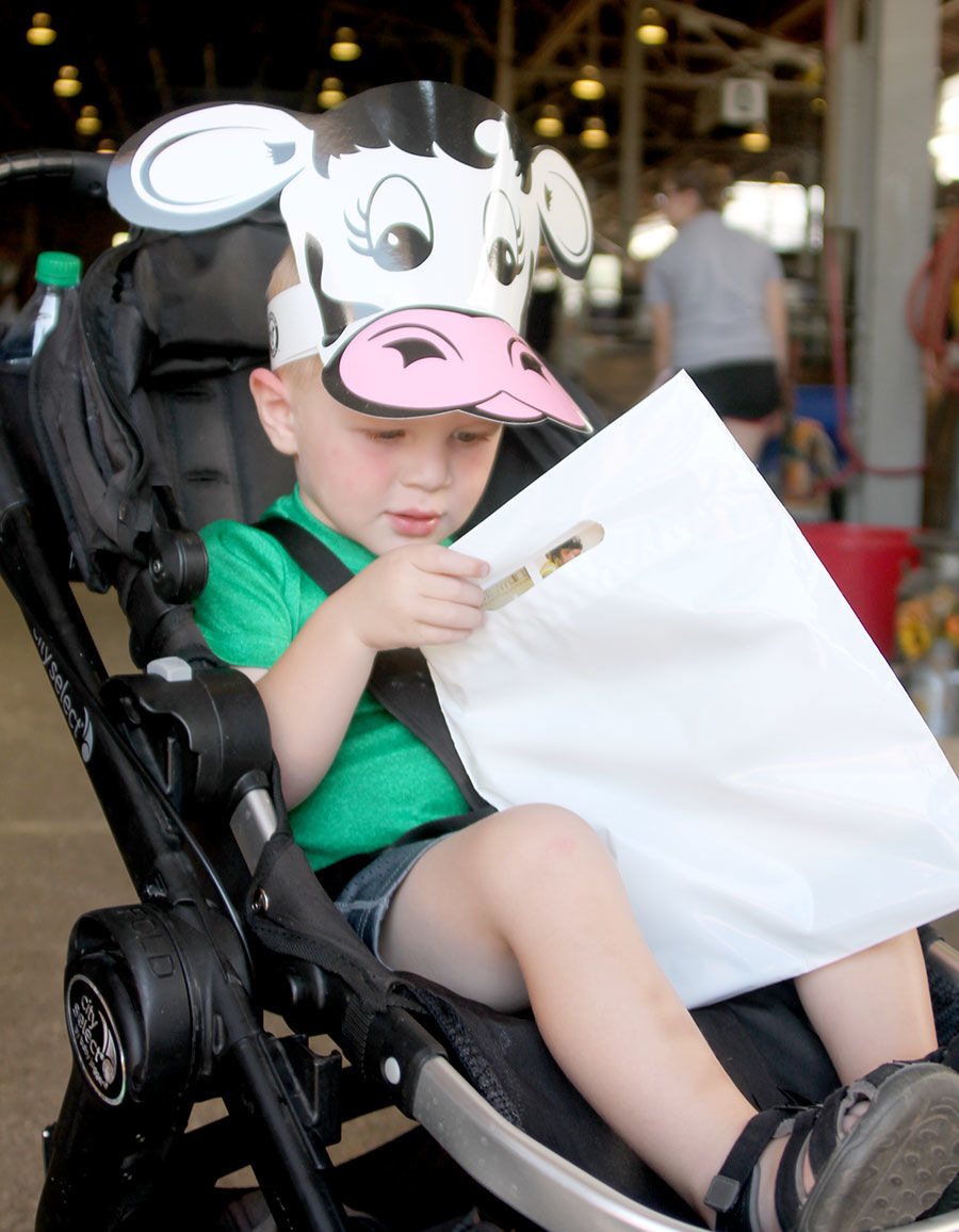 Two-year-old Cal Taylor of Okoboji gets a cow hat to wear at the fair.